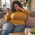 Femme relisant une conversation sur son telephone dans son salon en fin de journee. Illustration de l’article sur le bon moment pour proposer un rendez-vous